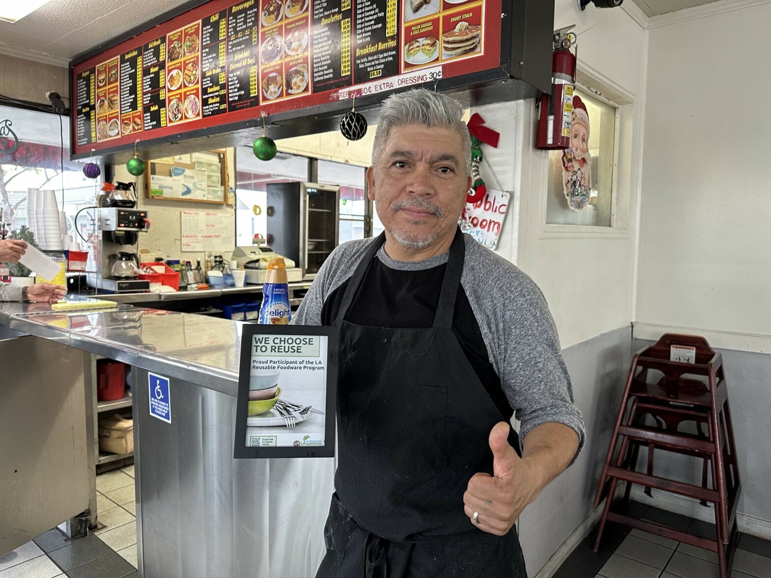 Rick's In & Out in Wilmington holding "Choose to Reuse" certificate
