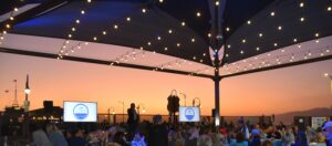 Coastal Connections past event with CEO speaking and sunset in the backdrop